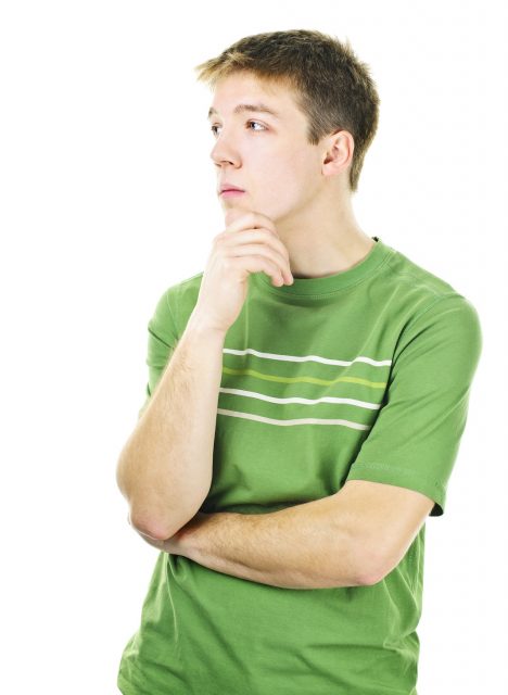 Thoughtful young man standing isolated on white background